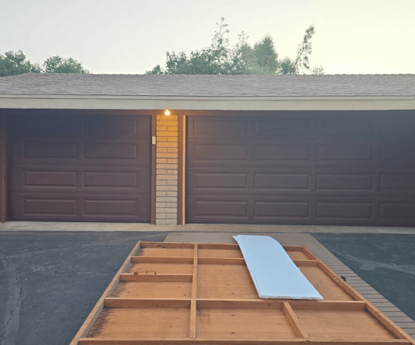 Garage door repair technicians replacing a broken spring in Alameda